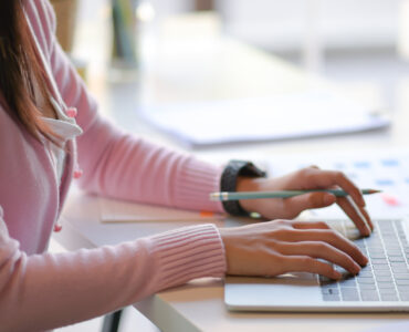 Cropped shot of Young women use laptop in modern personal office.